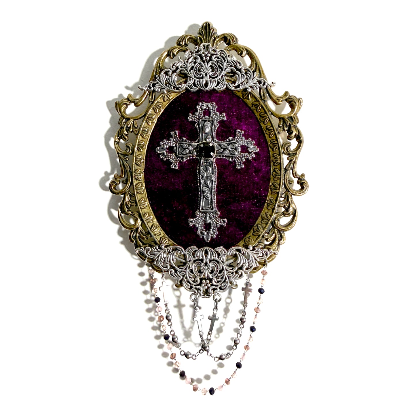 Decorative antique frame with silver cross design on a purple velvet background