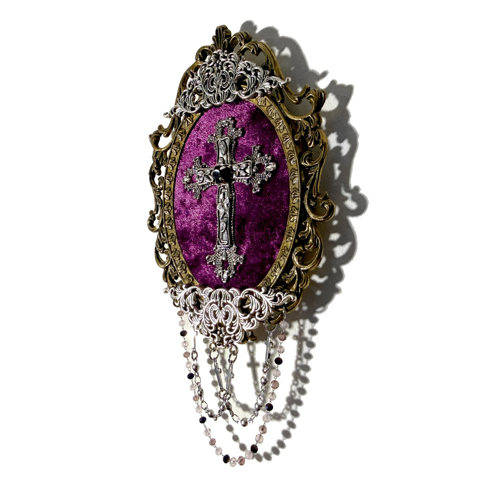 Decorative antique frame with silver cross design on a purple velvet background