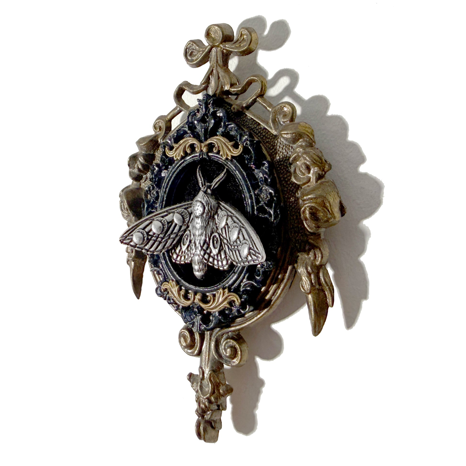 Decorative antique frame with silver moth fairy on black velvet 