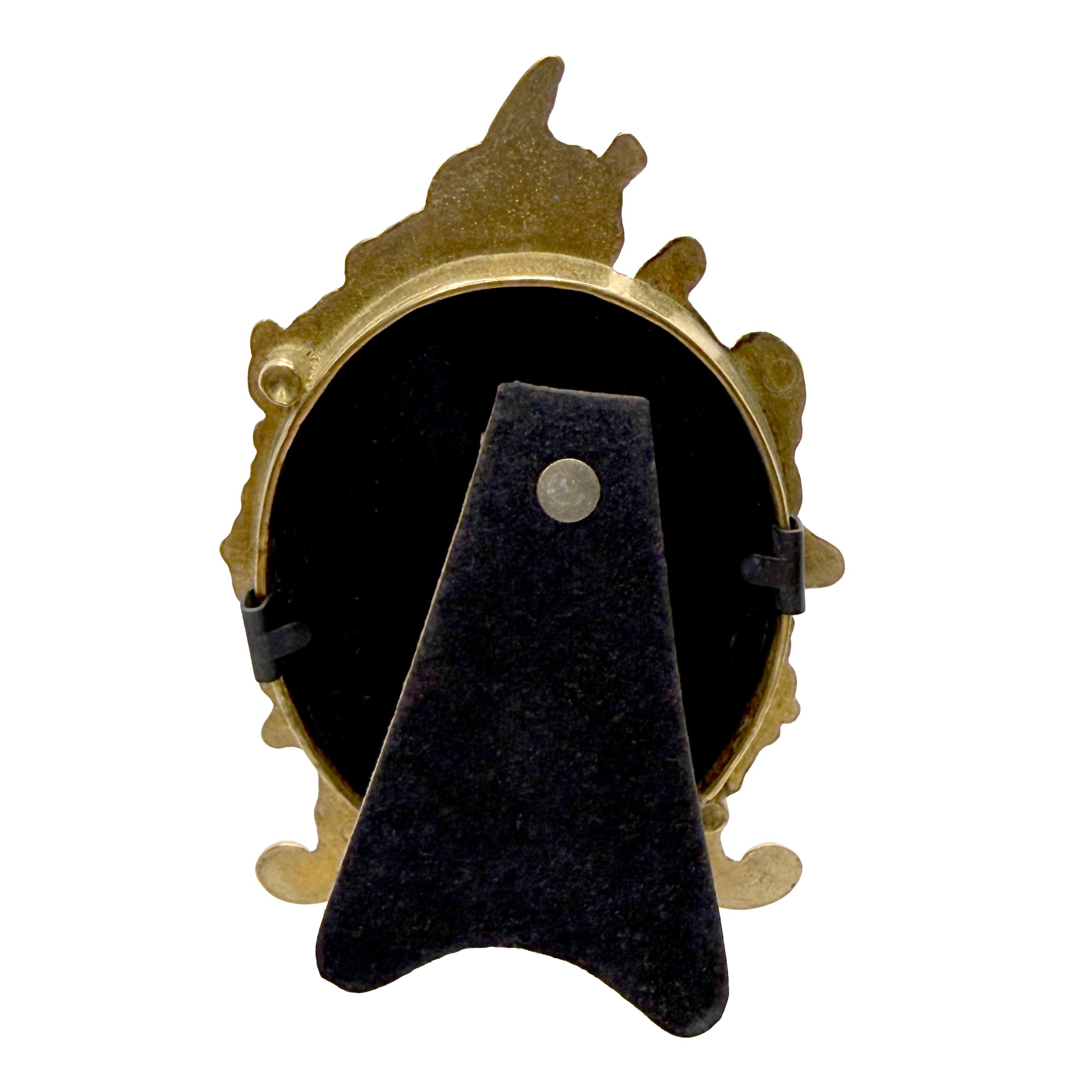 The back of a decorative antique frame with gold fairy on black velvet featuring a floral design on a white background